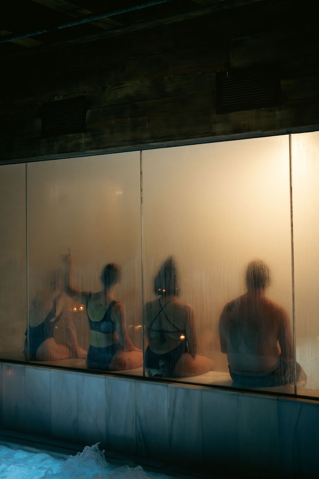 Guests seen through the misted glass of the steam room